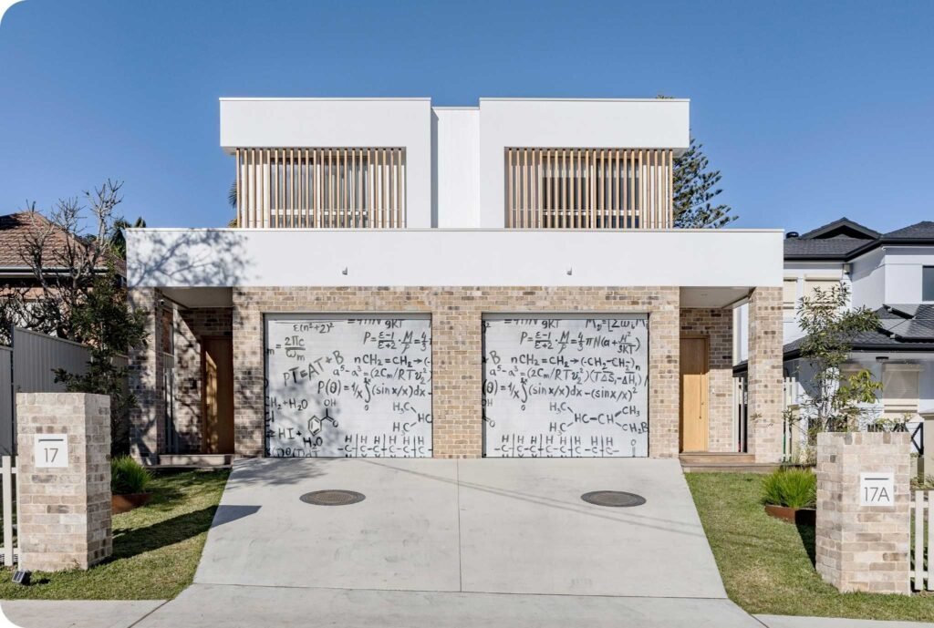 Modern duplex with brick facade and garages painted with scientific formulas.